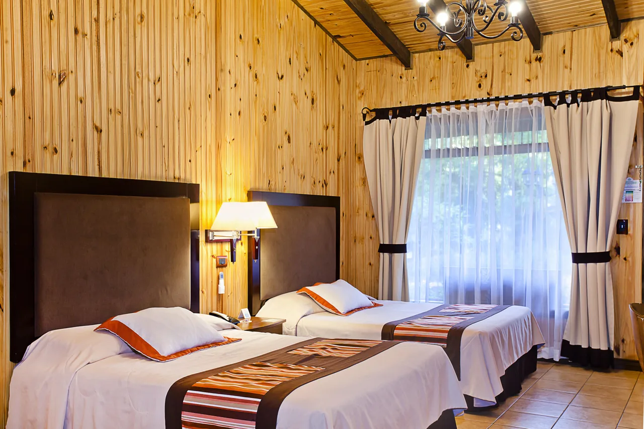 Inside the Standard room, its two beds and the window with the curtains drawn back