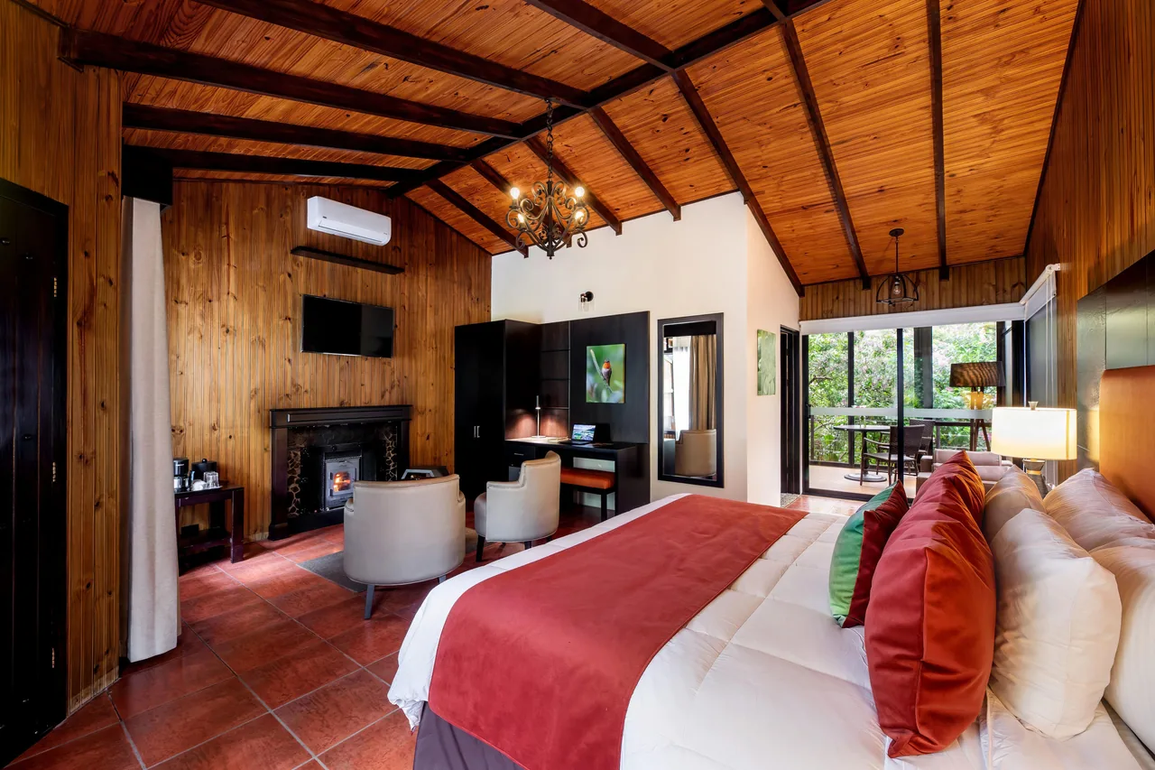 Master Suite con cama King, chimenea y la terraza acristalada al fondo