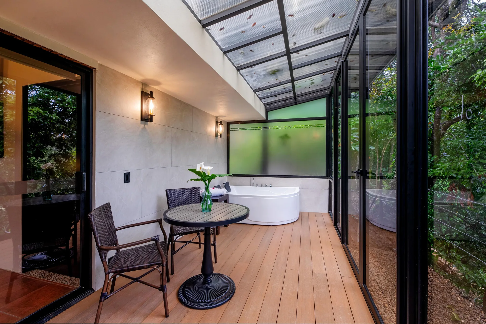 The Master Suite's glazed terrace, a table for two, the jacuzzi beyond and the forest on the other side of the glass
